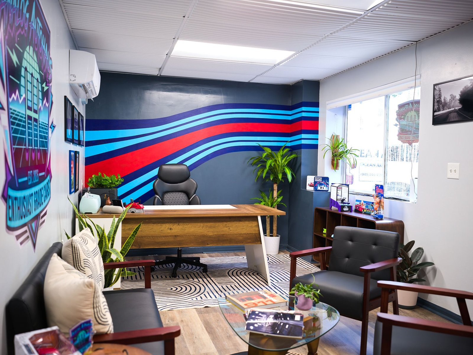Analog Autohaus office desk in front of the Martini racing stripe wall in the Office & Customer Lounge, Sarasota