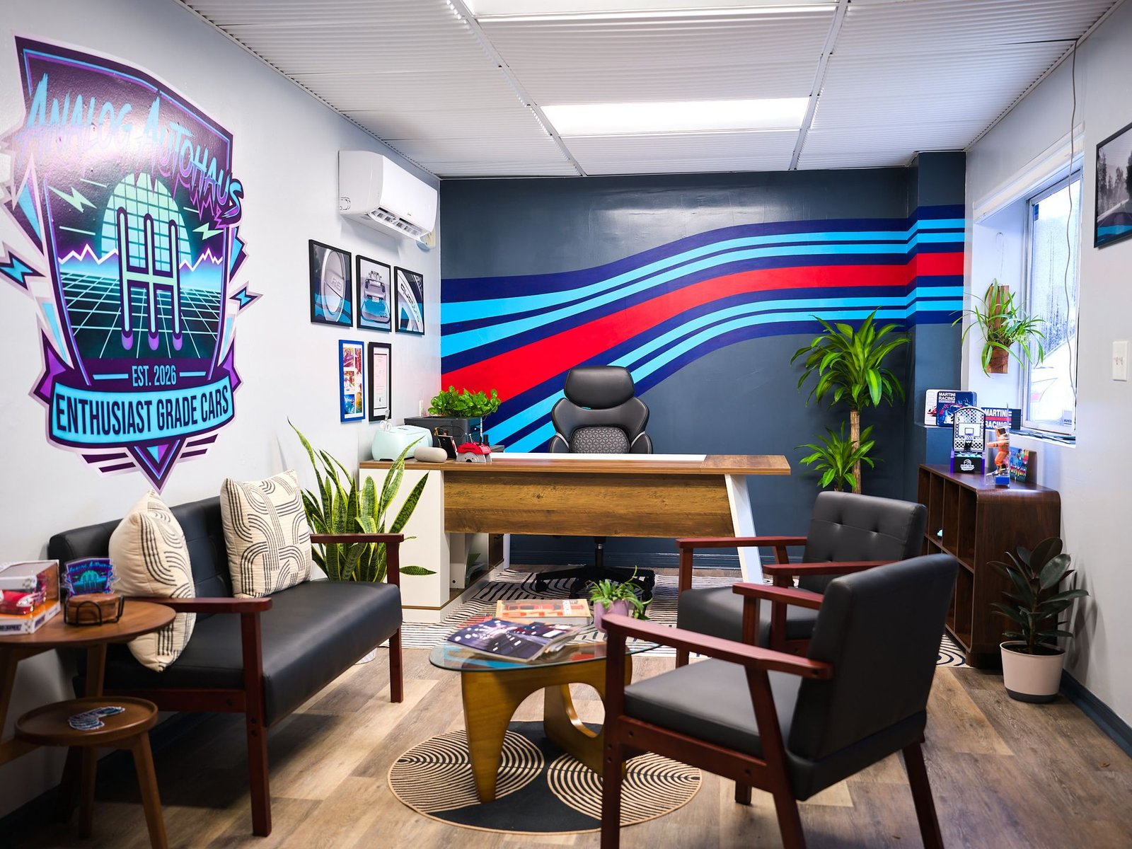 Analog Autohaus Office & Customer Lounge in Sarasota with Martini stripe wall, lounge seating, and retrowave logo mural